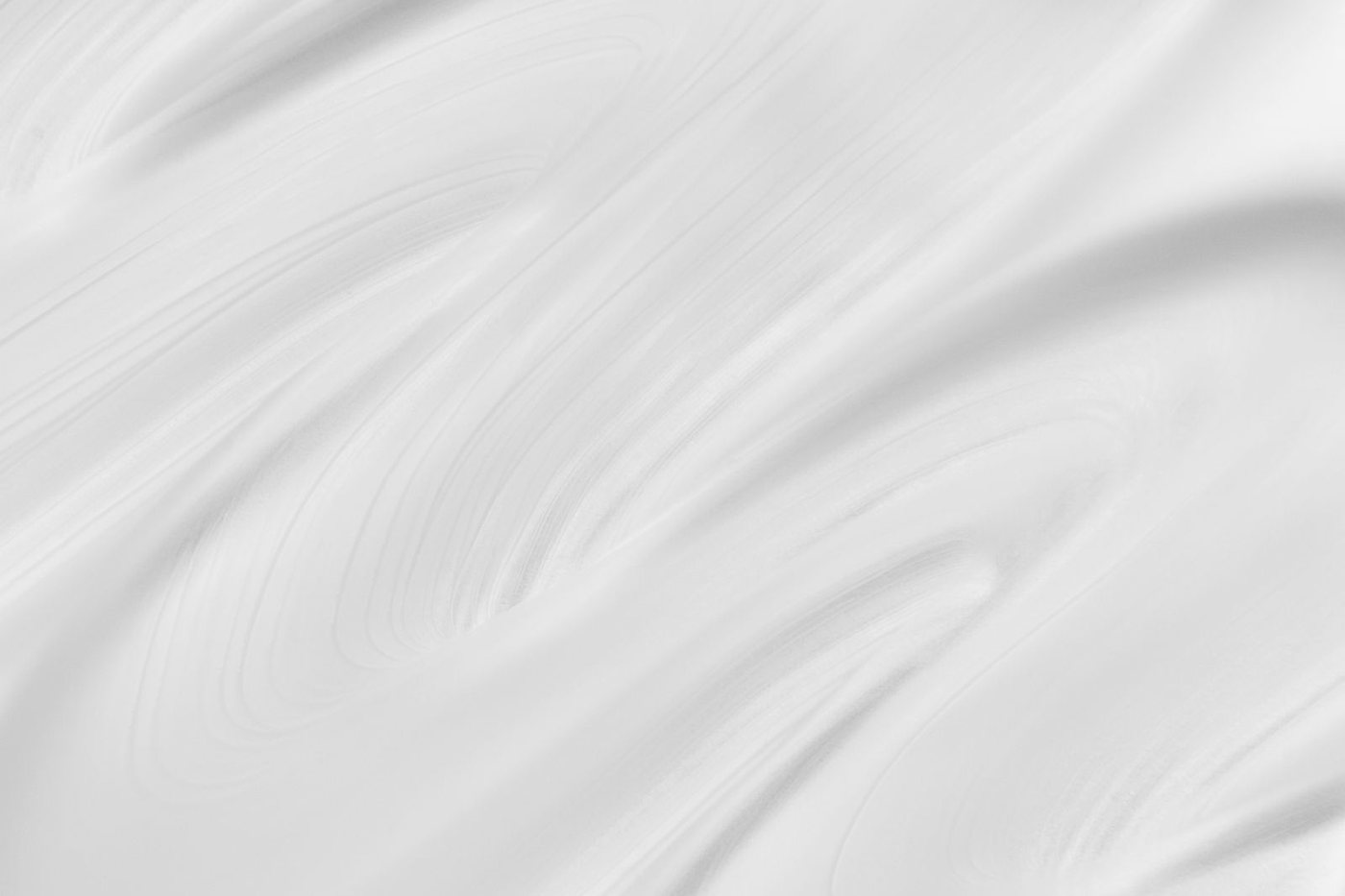 Smooth abstract white texture with creamy, swirling patterns.